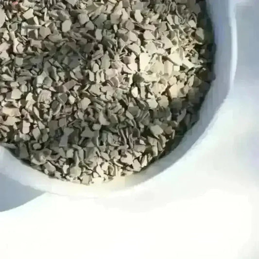 Oestergrit voor kippen in een voerbak, natuurlijke calciumbron voor sterke botten en betere spijsvertering.