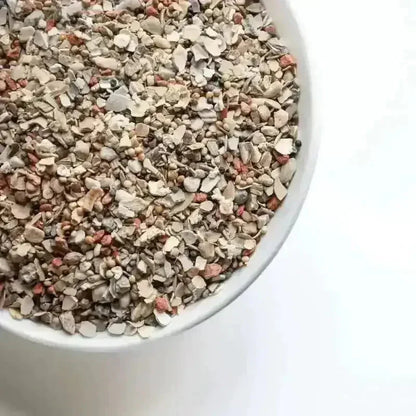 Close-up van Pikmix - De Spijsverteringsmix Voor Optimale Voedingsstofsopname met grit, oesterschelpen en zaden voor gezonde kippen.